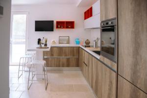 a kitchen with wooden cabinets and a counter with stools at Il TrullOzio in Castellana Grotte