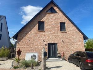 a red brick house with a black door at Ferienwohnung Sanddornidylle in Graal-Müritz
