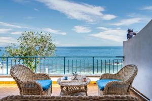 2 sillas y una mesa en un balcón con vistas al océano en Casa sulla spiaggia en Cala Gonone