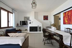Sala de estar con 2 camas y mesa de comedor en Casa sulla spiaggia, en Cala Gonone