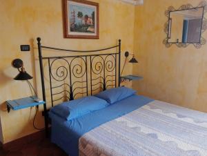 a bedroom with a bed with blue pillows and a mirror at Locanda D'Ogliastra, in Triei