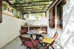 patio con mesa, sillas y ventana en Casa sulla spiaggia, en Cala Gonone
