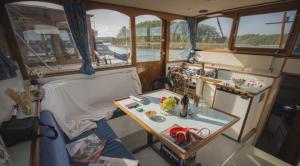 a small boat with a table in the middle at KUHNLE-TOURS Schlafen im Hafen in Rechlin