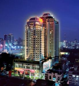 un perfil urbano por la noche con un edificio alto en Grand Diamond Suites Hotel, en Bangkok