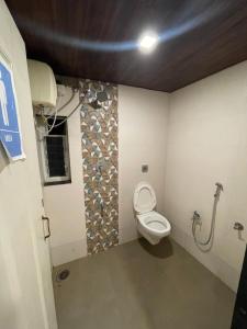 ein Bad mit WC in einem Zimmer in der Unterkunft Monalisa lawns in Thane
