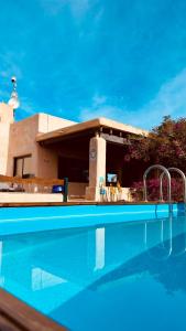 una piscina frente a una casa con un edificio en Villa Turquoise Formentera, en Sant Ferran de Ses Roques