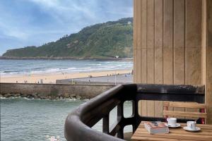 a balcony with a table with a view of the beach at Be Bop by FeelFree Rentals in San Sebastián