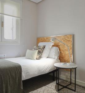 1 dormitorio con 1 cama con lámpara y mesa en Be Bop by FeelFree Rentals, en San Sebastián