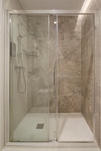 La salle de bains est pourvue d'une douche avec une porte en verre. dans l'établissement Be Bop by FeelFree Rentals, à Saint-Sébastien