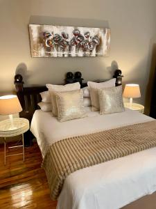 a bedroom with a bed with white sheets and pillows at Moments Guest House in Klerksdorp