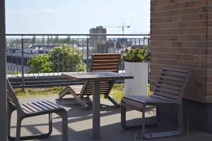 uma mesa de piquenique e 2 cadeiras numa varanda em Roof Terrace Old Town Apartments with private parking em Gdansk