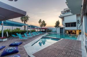 a swimming pool with blue chairs next to a building at Tema 242 Hotel in Antalya