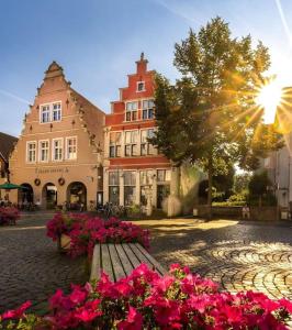 a park bench in front of a building with flowers at Ferienwohnung an der Steinfurter Aa in Steinfurt
