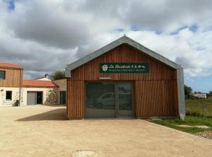 a garage with a car parked inside of it at LA BORDERIE - MAISON DES RANDONNEES - Gîte étape - gîte de groupe in Vairé