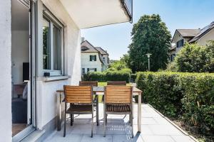 un tavolo e sedie seduti sul portico di una casa di Cooldis 12 !Gratis Parken, Free Parking! a Kreuzlingen