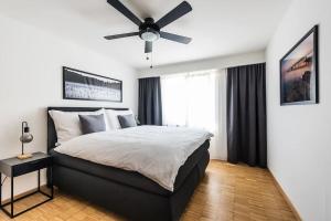 a bedroom with a large bed with a ceiling fan at Cooldis 12 !Gratis Parken, Free Parking! in Kreuzlingen