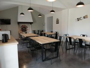 a dining room with tables and chairs and a fireplace at LA BORDERIE - MAISON DES RANDONNEES - Gîte étape - gîte de groupe in Vairé