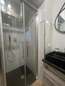 a bathroom with a glass shower with a sink at ESSE boutique homes in Cefalù