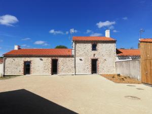 a large stone building with a red roof at LA BORDERIE - MAISON DES RANDONNEES - Gîte étape - gîte de groupe in Vairé +1 photo