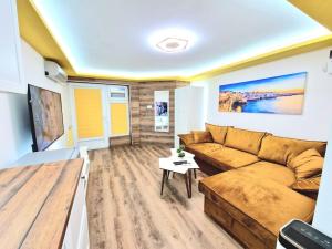 a living room with a couch and a tv at Yellow studio in Varna City