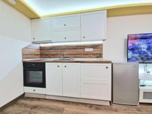 a kitchen with white cabinets and a sink and a refrigerator at Yellow studio in Varna City