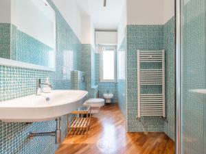 baño con lavabo y azulejos azules en Palma Paradise Escape, en Cagliari