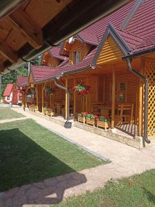 a large wooden house with flowers on it at Vila Perisic in Kaludjerske Bare