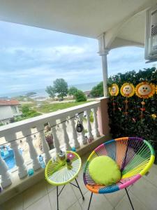 a balcony with two chairs and a view of the ocean at Perla Del Mar Studio PANORAMA First line in Lozenets