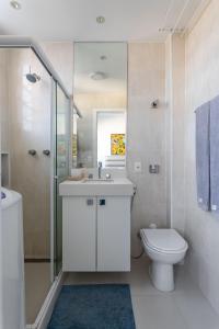 Baño blanco con lavabo y aseo en Loft Catete, en Río de Janeiro