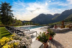 a pool with benches and a view of mountains at Hotel Castel Mani in San Lorenzo in Banale