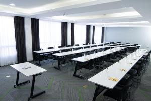 Cette grande chambre comprend des tables blanches et des chaises noires. dans l'établissement Seo Hotel, à Machakos