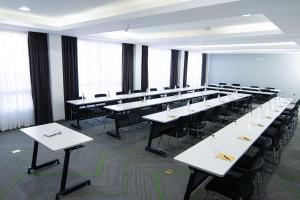 a large room with white tables and black chairs at Seo Hotel in Machakos