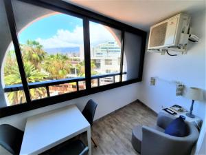Zimmer mit einem großen Fenster mit einem Tisch und einem Stuhl in der Unterkunft ZioCarlo/Las Americas in Playa de las Americas