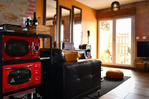 ein Wohnzimmer mit einem Sofa und einer Mikrowelle in der Unterkunft Appartement romantique avec jacuzzi et terrasse in Perpignan