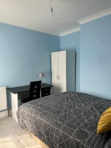 a bedroom with a bed and a desk and a desk at Eva Suites in Gillingham