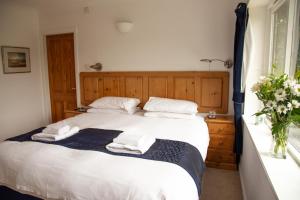a bedroom with a bed with two towels on it at Sladen Lodge in Hathersage