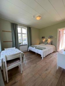 1 dormitorio con 2 camas y ventana en Pensionat Söderåsen en Ljungbyhed