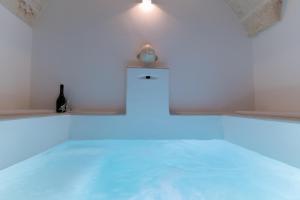 a white room with a bottle of wine and a blue light at Suite L' Alcova in Fasano +25 photos