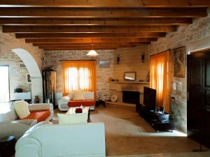- un salon doté de meubles et d'un mur en pierre dans l'établissement Hephaestus Villa, à Kapparianá