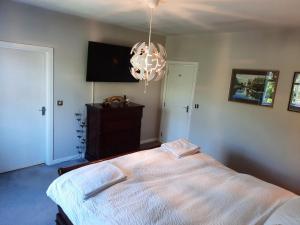 a bedroom with a bed and a flat screen tv at Stunning 55 Riverun on the banks of the lovely Riv in Belturbet