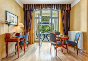 ein Esszimmer mit Tisch und Stühlen und einem Fenster in der Unterkunft Villa Seeschloss in Heringsdorf
