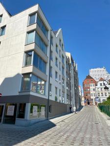 a large building on a cobblestone street at Apartament Środowa by Prestige Home in Szczecin