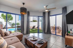 una sala de estar con un sofá y una mesa en Luxury 3-bedroom villa with heated private pool - in Marina Rubicon, Playa Blanca, Lanzarote, en Playa Blanca