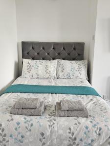 un letto con due asciugamani e due cuscini sopra di Edgerton Studios a Huddersfield