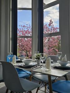 een eetkamer met een tafel en een groot raam bij Edgerton Studios in Huddersfield