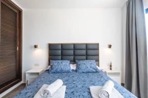 Un dormitorio con una gran cama azul con almohadas azules en Luxury 3-bedroom villa with heated private pool - in Marina Rubicon, Playa Blanca, Lanzarote, en Playa Blanca 23 fotos más