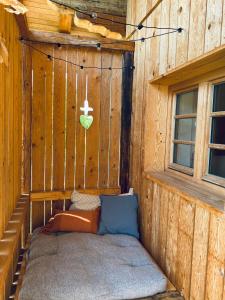 a corner of a wooden house with a bed in it at Ferienwohnung Bergliebe Höhenmoos in Rohrdorf