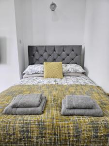 Una cama con dos almohadas encima. en Edgerton Studios, en Huddersfield