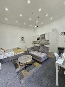 uma sala de estar com um sofá, uma cama e uma mesa em Edgerton Studios em Huddersfield