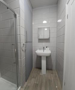 uma casa de banho branca com um lavatório e um chuveiro em Edgerton Studios em Huddersfield